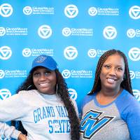Two women posing in front of GV back drop